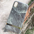 Plastic iPhone case with abstract marble pattern print in multiple colour options on a wooden table.