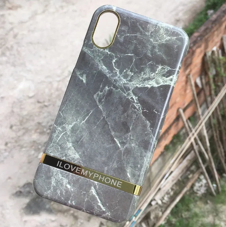 Plastic iPhone case with abstract marble pattern print in multiple colour options on a wooden table.