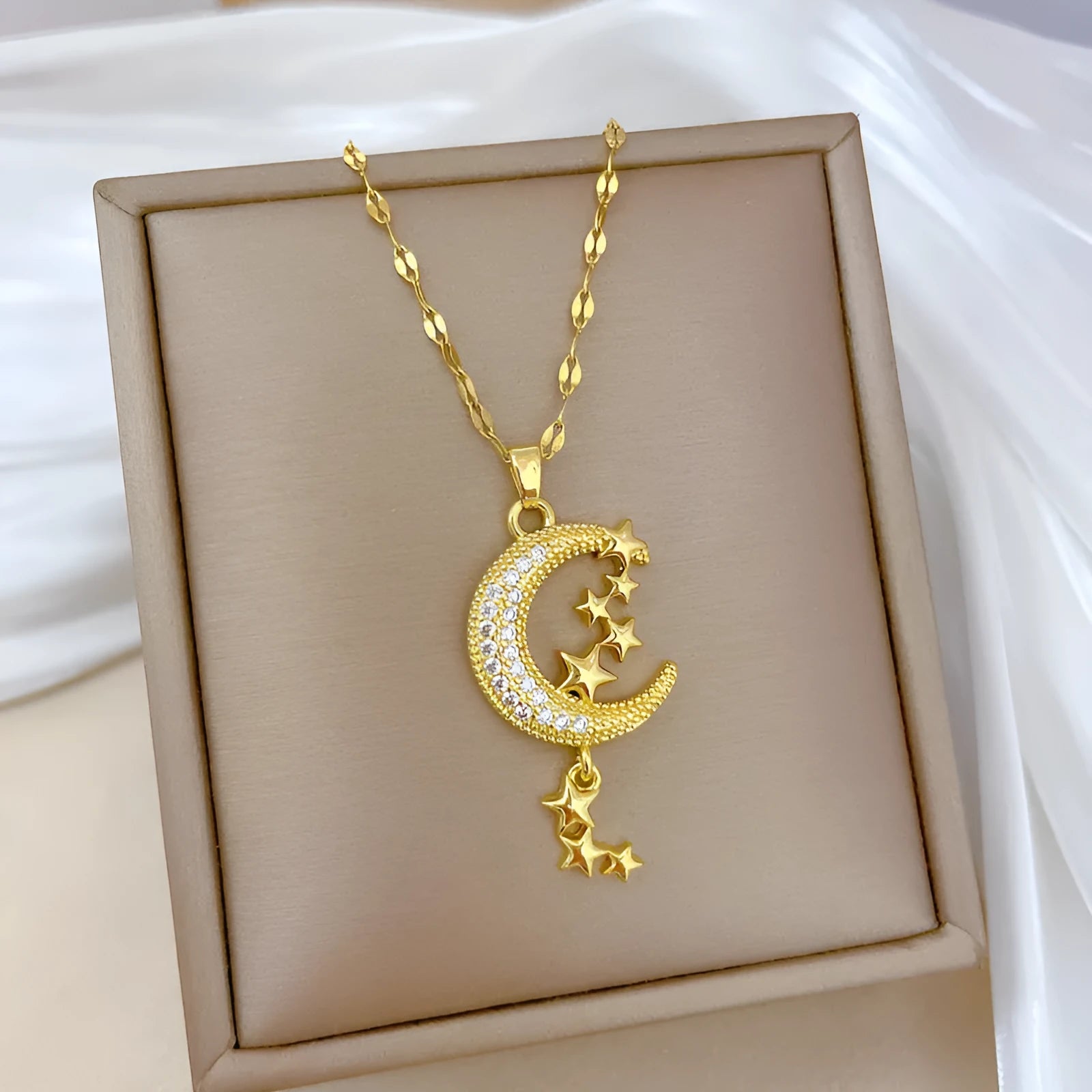 Geometric moon pendant necklace with crystals and tassel detail on an adjustable stainless steel chain.