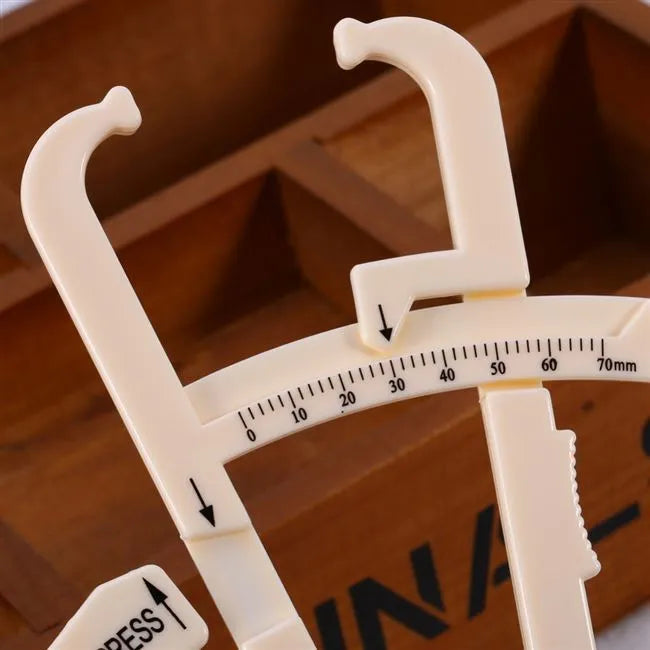 Compact acrylic fat caliper for body fat measurement, showing size and scale.