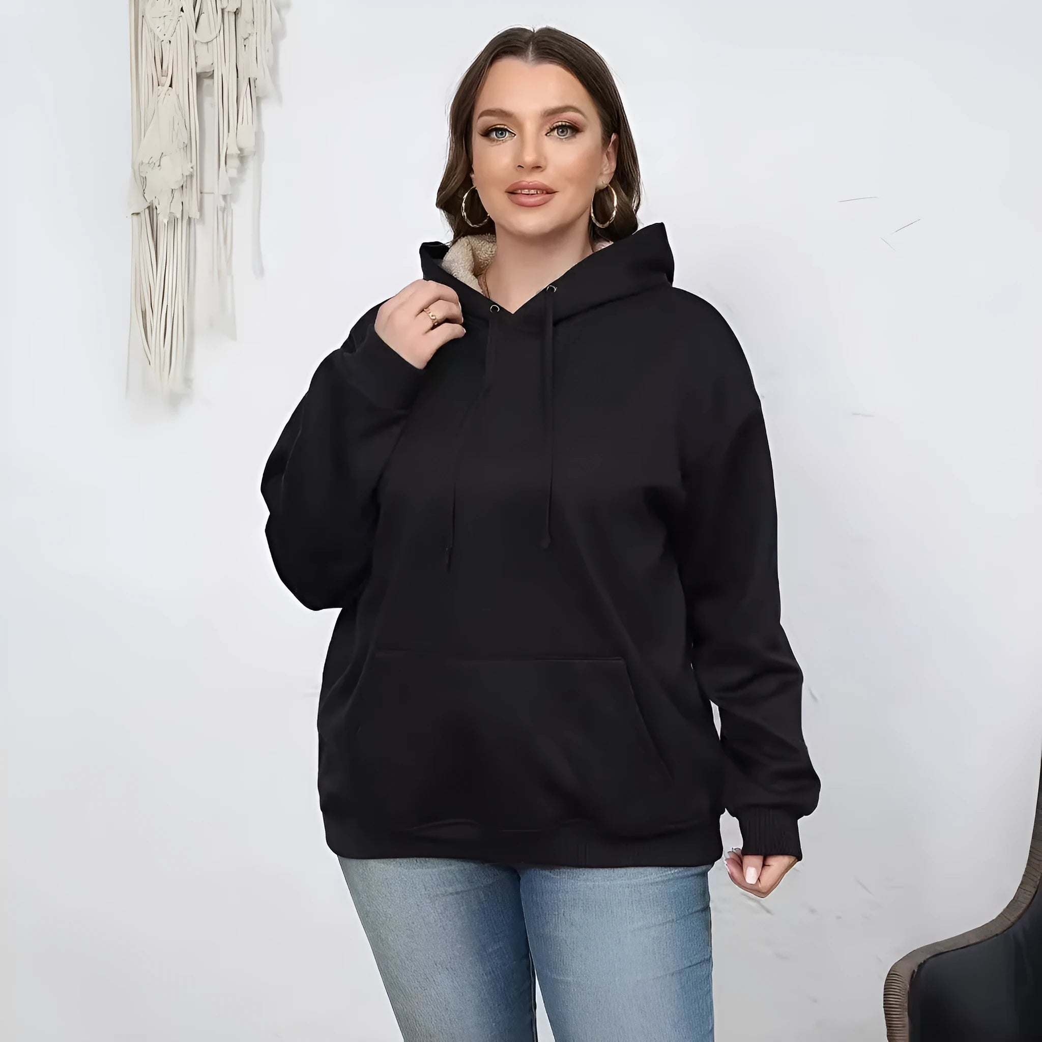Women's loose hooded sweater with pockets in black colour showing 3D pattern detail