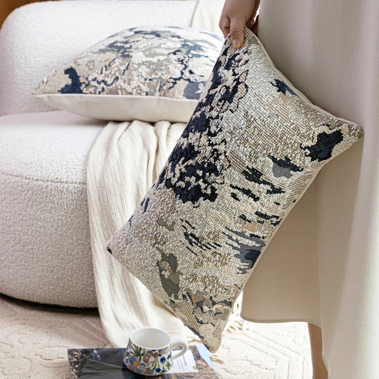 Blue floral antique pattern wool blend cushion cover and feather velvet pillow on a sofa.