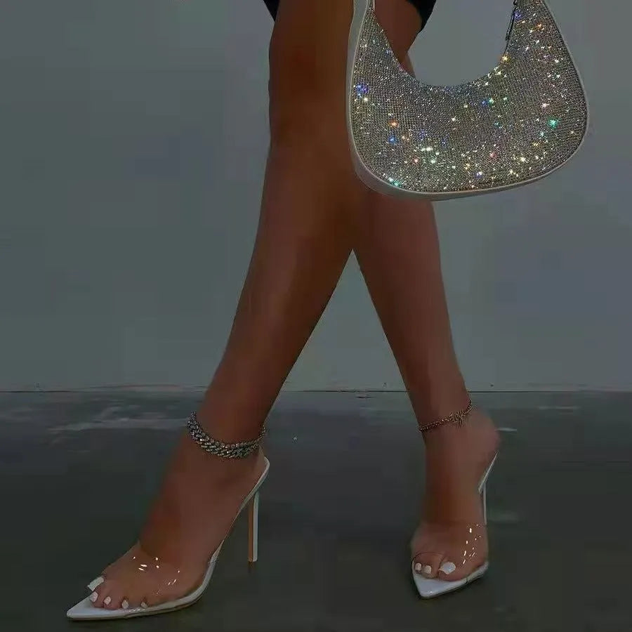 Women's black ultra-high vamp stiletto heel slipper with pointed toe on a white background.