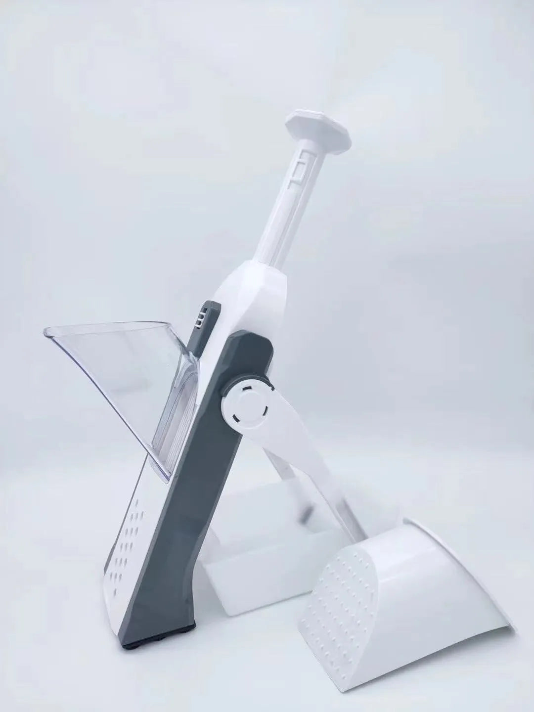 White and blue multifunctional vegetable slicer with stainless steel blades on a kitchen counter.