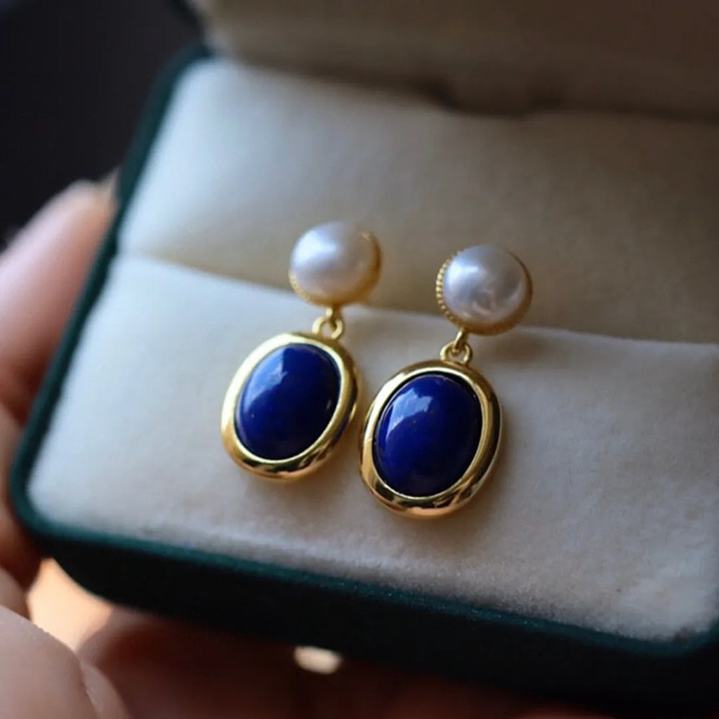A pair of simple sterling silver earrings featuring deep blue lapis lazuli pearls.