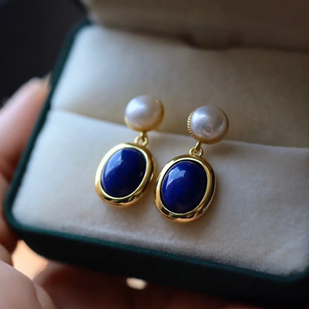 A pair of simple sterling silver earrings featuring deep blue lapis lazuli pearls.