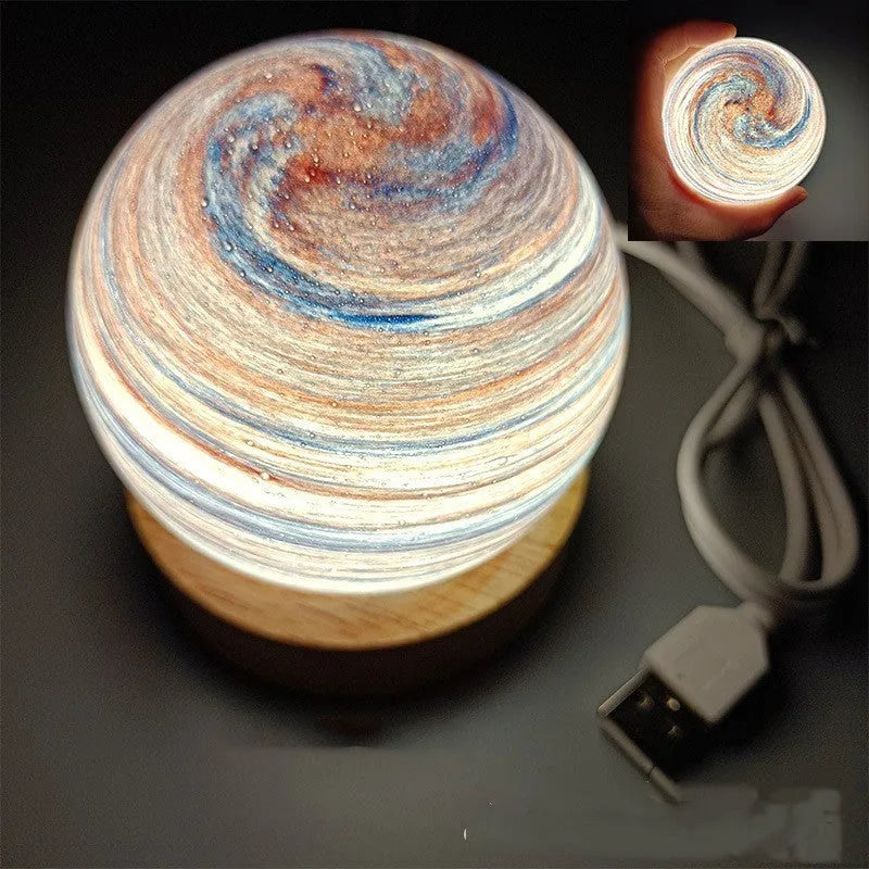 Modern planet-shaped USB night light with dimming on a desk.