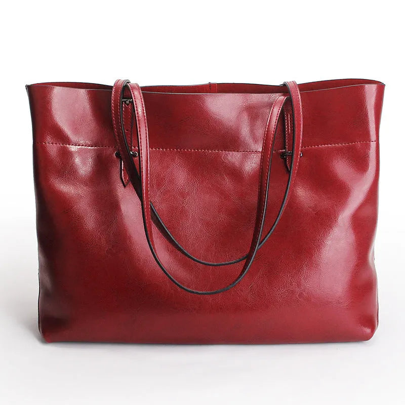 Brown waxed cowhide cross-body handbag showing front flap and adjustable shoulder strap.