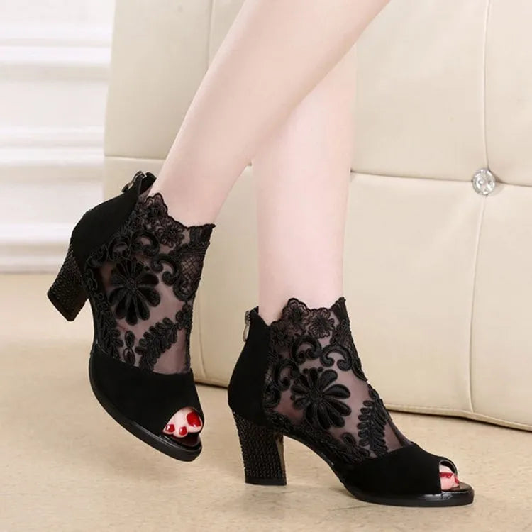 Black women's gladiator sandals with flower lace upper, square heel, and back zip closure.