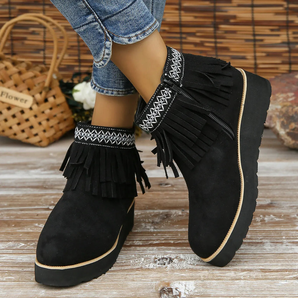 Women's suede wedge ankle boot with tassel detail, side zip, and a thick rubber sole.