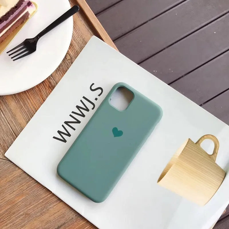 Solid-colour silicone phone case for iPhone, shown in dark green, flour, light green, light pink, purple, and red.