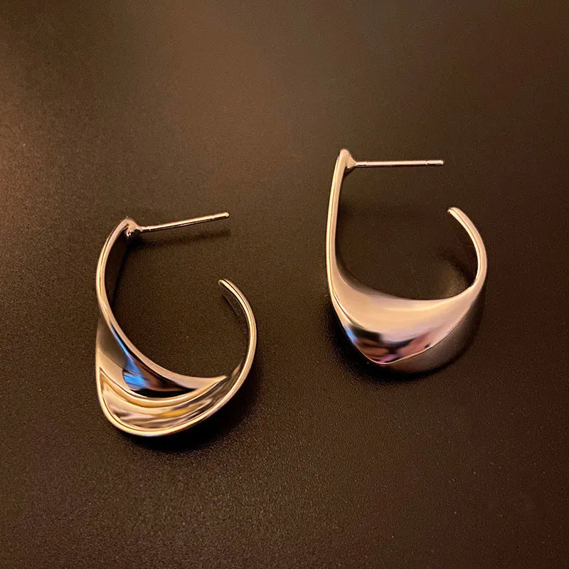 Geometric twist design metal earrings in gold or silver finish with round elements
