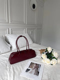 Women's solid colour genuine cowhide leather oval single-shoulder bag in brown with visible sewing thread detail.