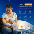 White cylindrical touch control bedside night light with USB charging cable.