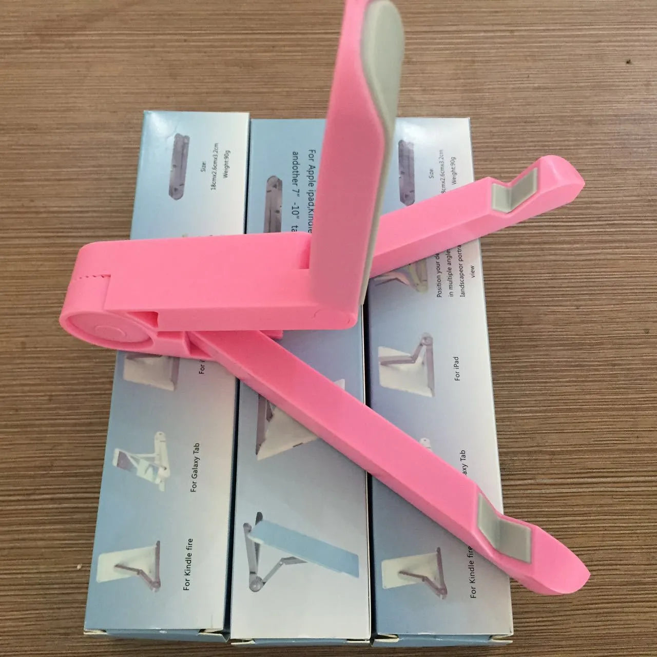 Black foldable tablet holder displaying smartphone in landscape position on desk