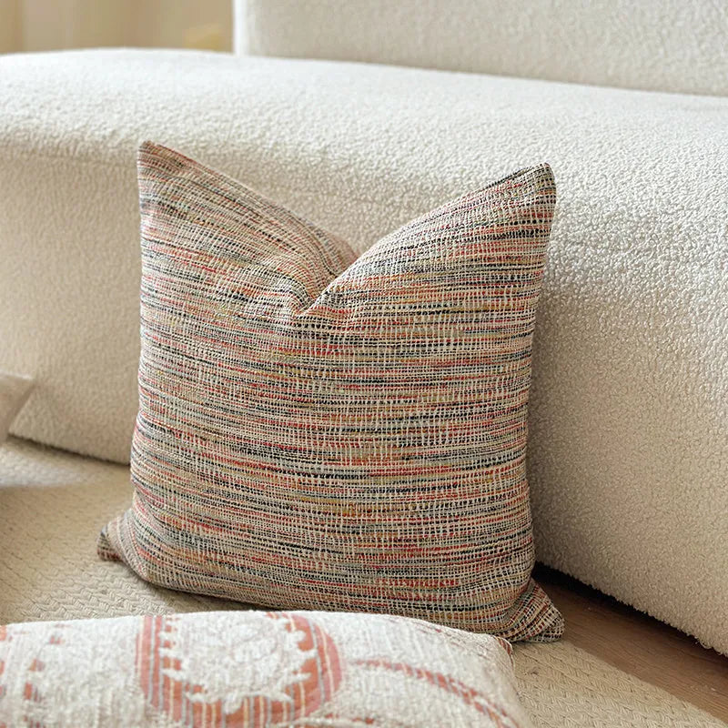 Amber American-style jacquard pillow cover with paisley and flower pattern on a sofa.