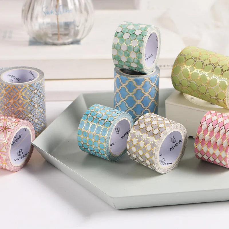 Roll of Alice in Wonderland themed decorative tape with a bronzed finish on Japanese paper, showing colour options.