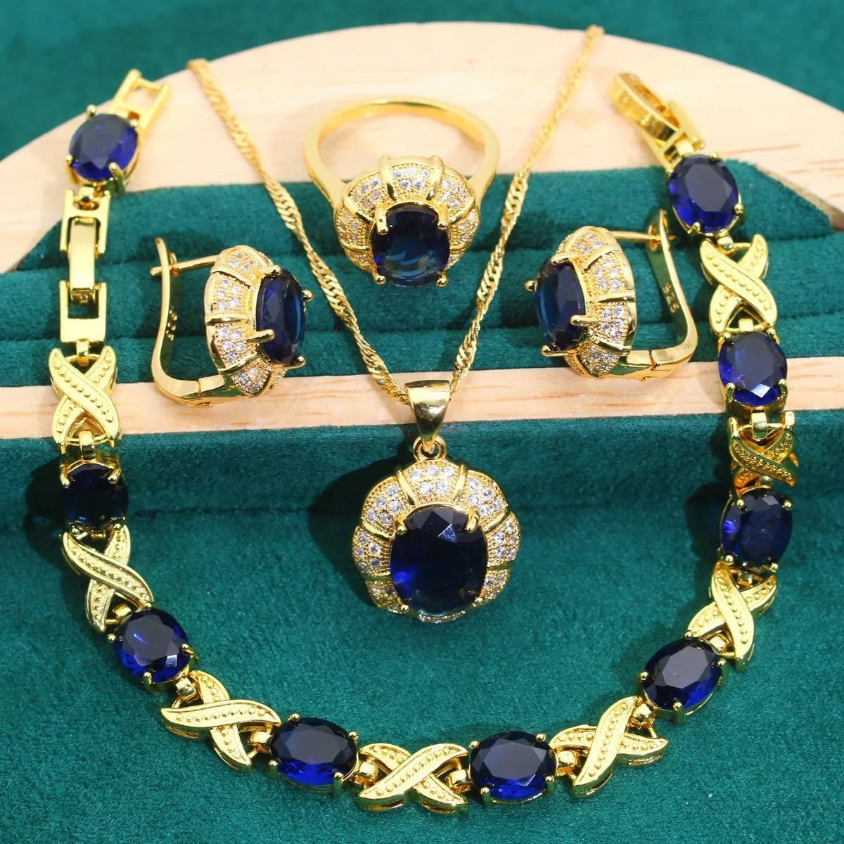 18k gold plated zircon jewellery set with necklace, earrings, ring, and bracelet on blue background