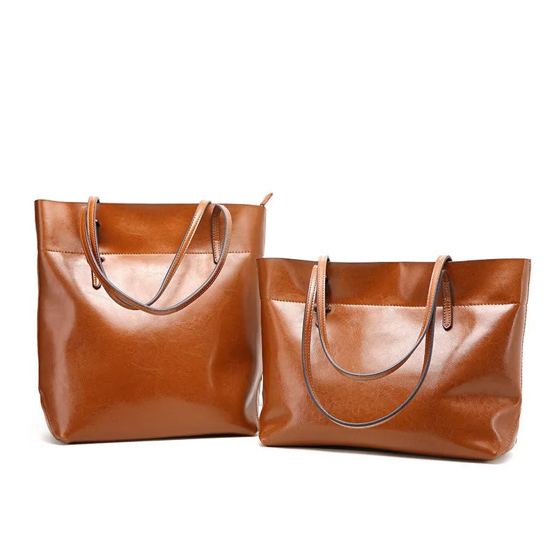 Brown waxed cowhide cross-body handbag showing front flap and adjustable shoulder strap.