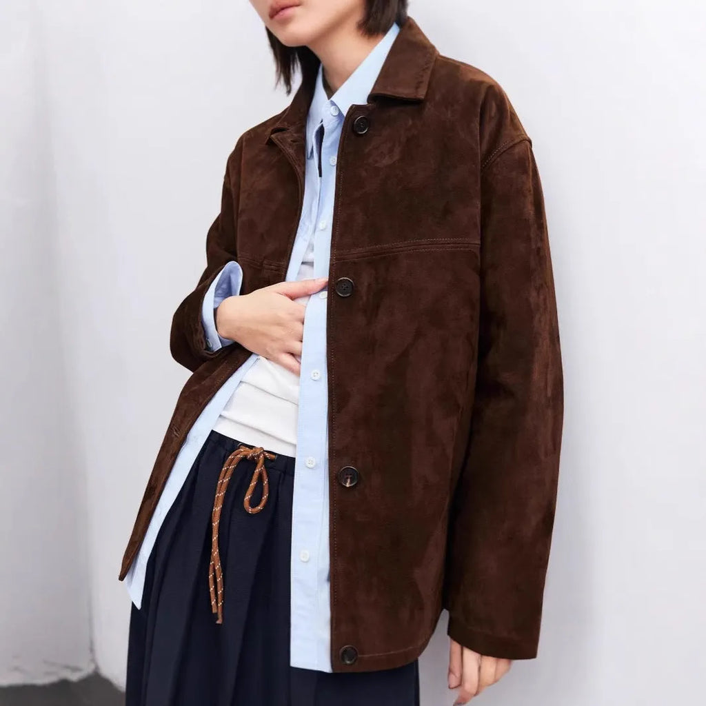Yellow brown retro women's coat with Peter Pan collar and leather belt on a hanger.