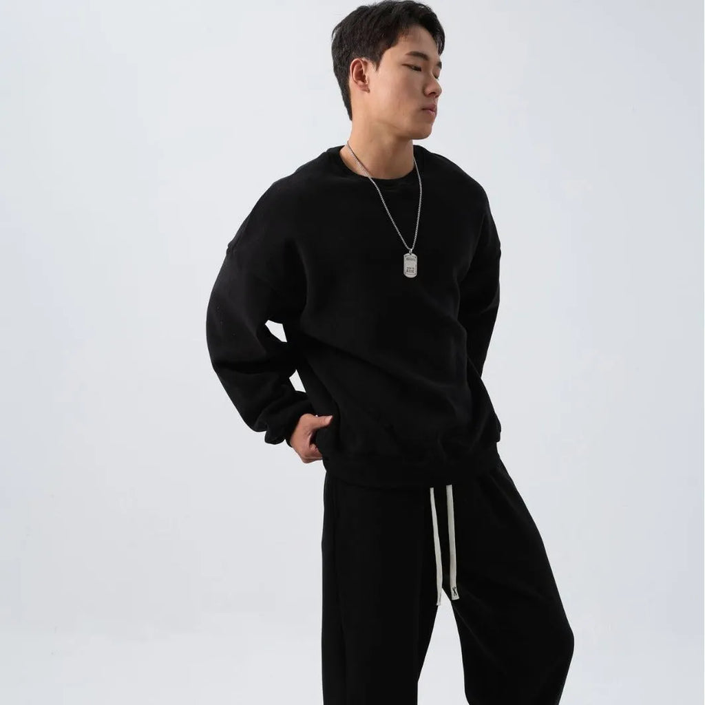 Man wearing a loose black polar fleece winter sports suit with crew neck coat and trousers