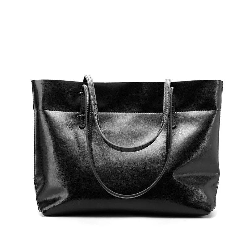 Brown waxed cowhide cross-body handbag showing front flap and adjustable shoulder strap.
