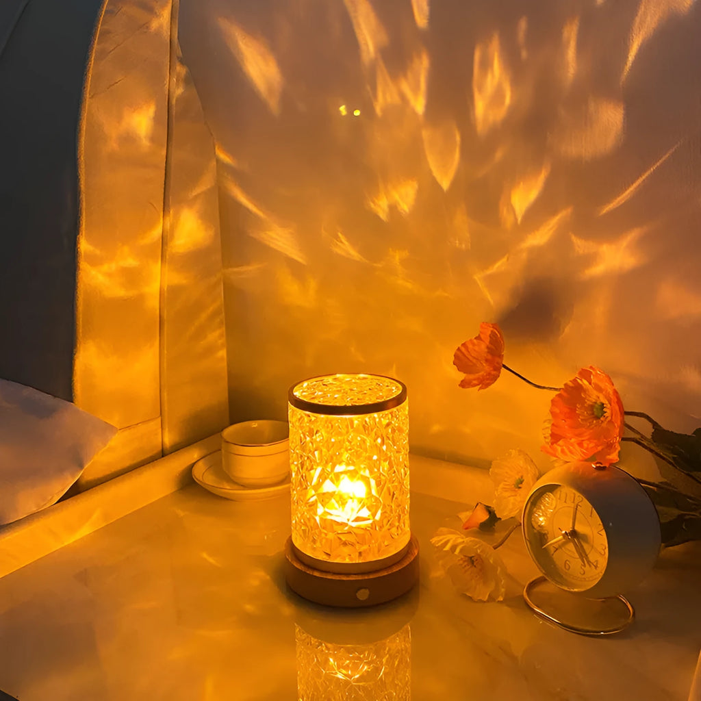 Small rotating water ripple night light on a wooden base with a USB cable.