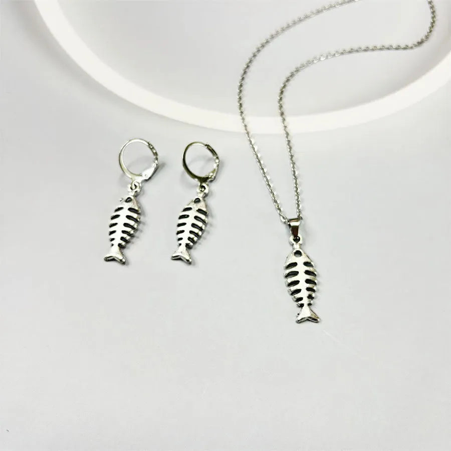 Fishbone pendant necklace and matching earrings set with adjustable chain on grey background
