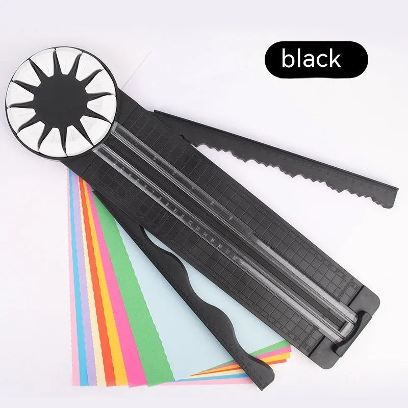 Pink and black 12-in-1 dotted line plastic rotary paper cutting machine on a craft table.