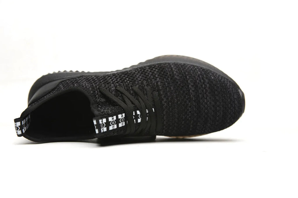 Low-cut black safety work shoes with a steel toe cap on a grey background.