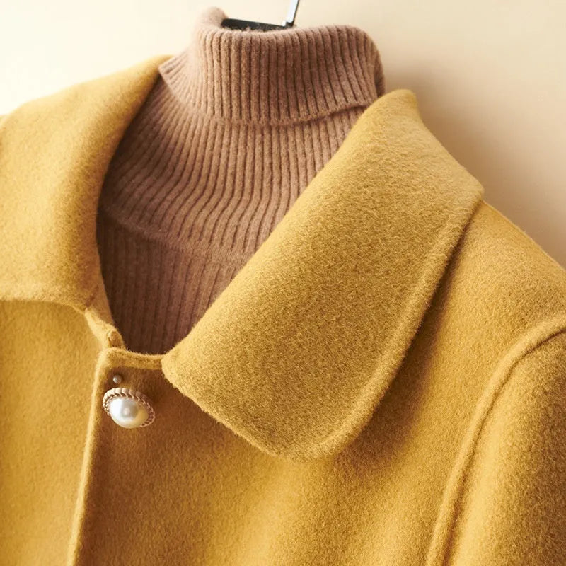 Women's solid colour wool coat with a doll collar and pearl buckle, shown in a mid-length cut.