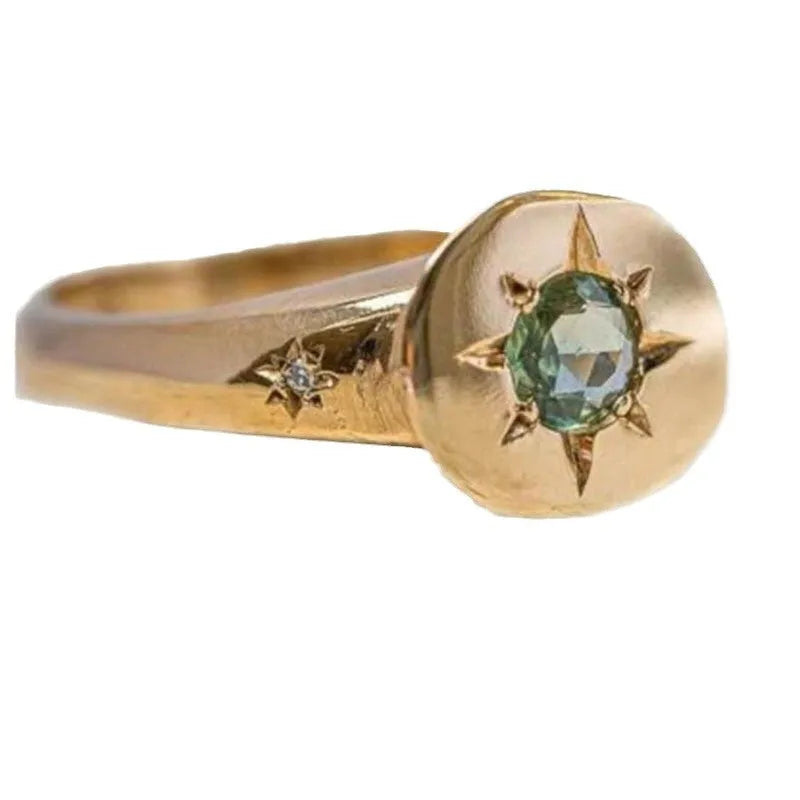 Gold-colour adjustable ring with oval band and central star-shaped zircon stone in a six-prong setting.