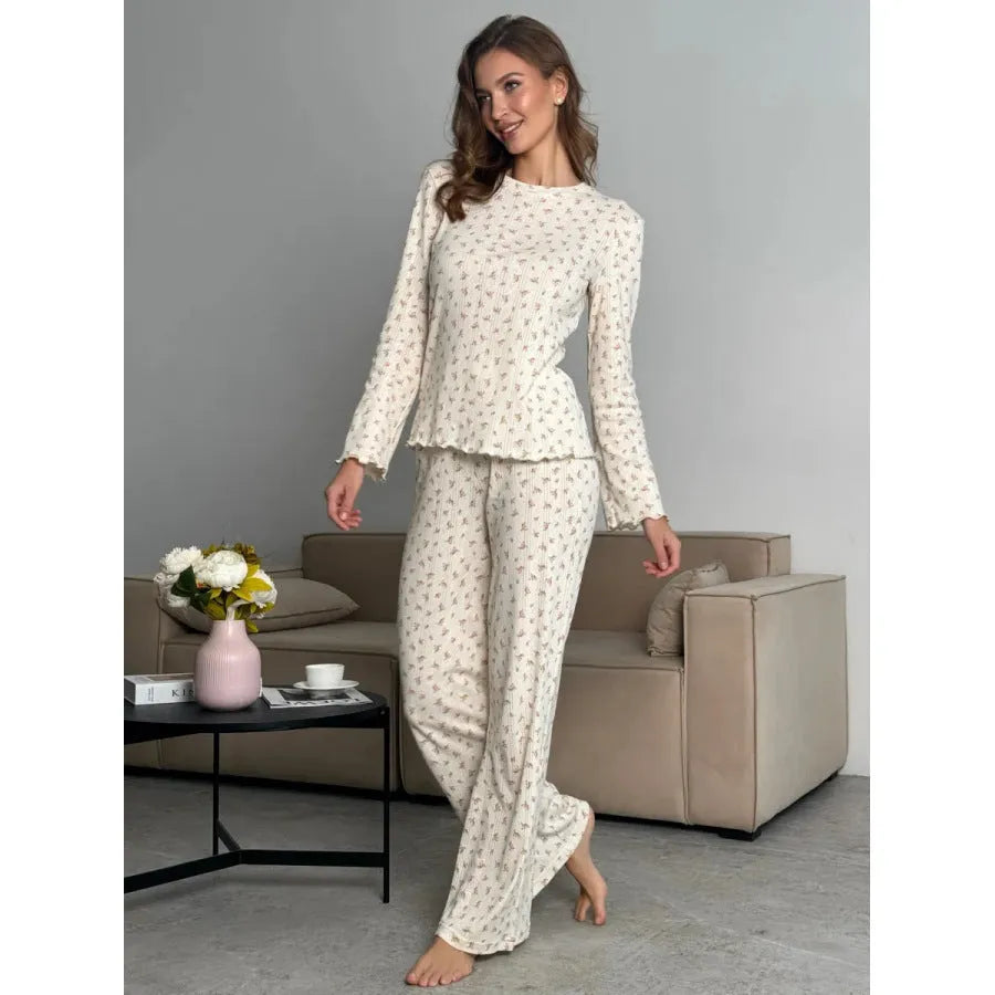 White women's floral print bell sleeve top and wide leg pants suit laid flat.