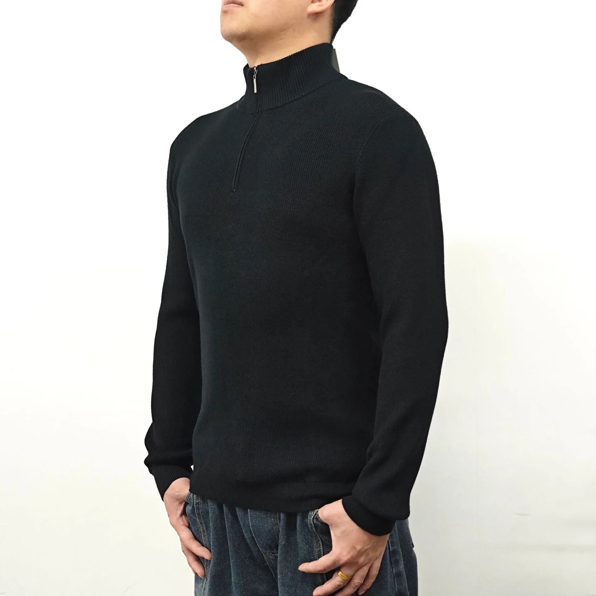 Man wearing a grey zip-front half-turtleneck sweater, a casual long-sleeve pullover.