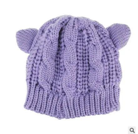 Hand knitted red wool beanie with 3D cat ears on a white background