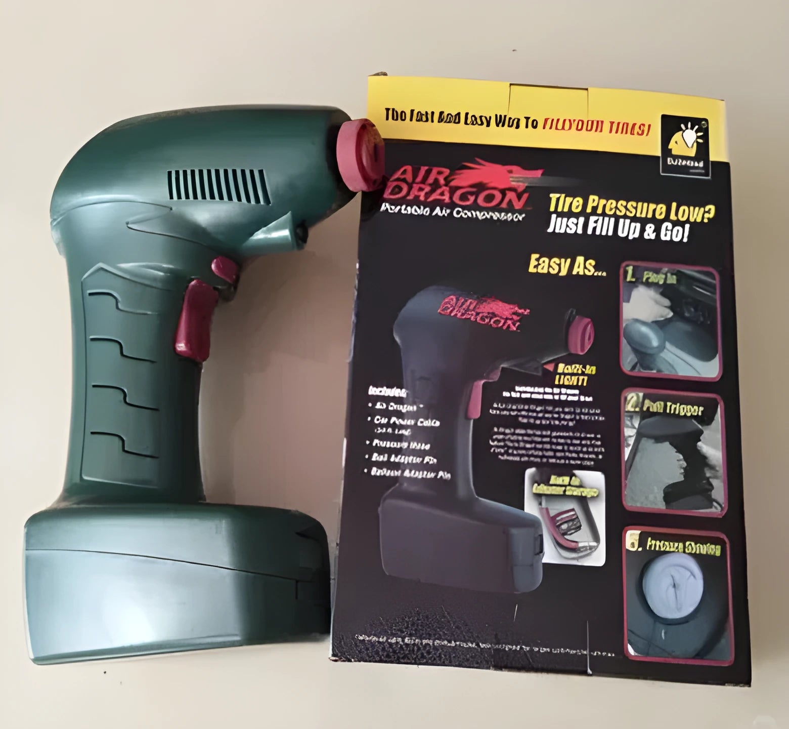 Black portable car tyre inflator with digital display and LED light on a coiled power cable.