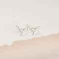Women's gold and silver bow or cross stud earrings with geometric designs