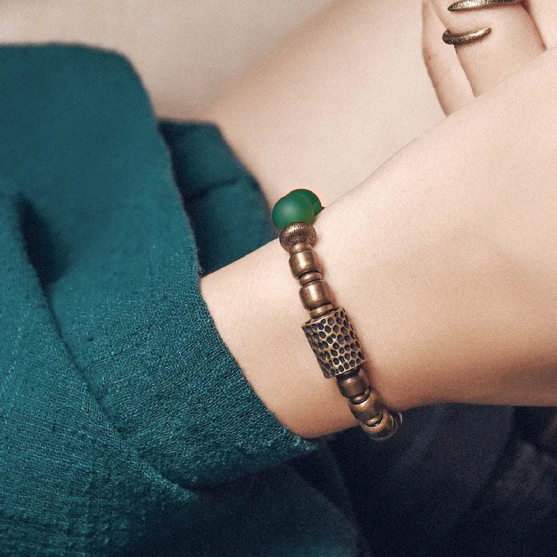 Retro ethnic style couples bracelet with green or red agate beads on a wrist.