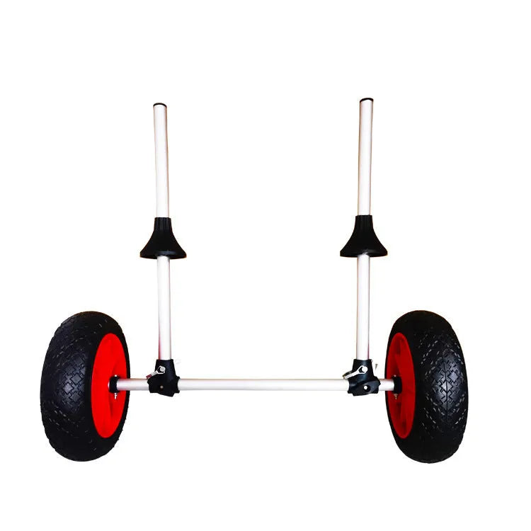 Foldable aluminium kayak cart with solid rubber tyres and black securing straps on a sandy beach.