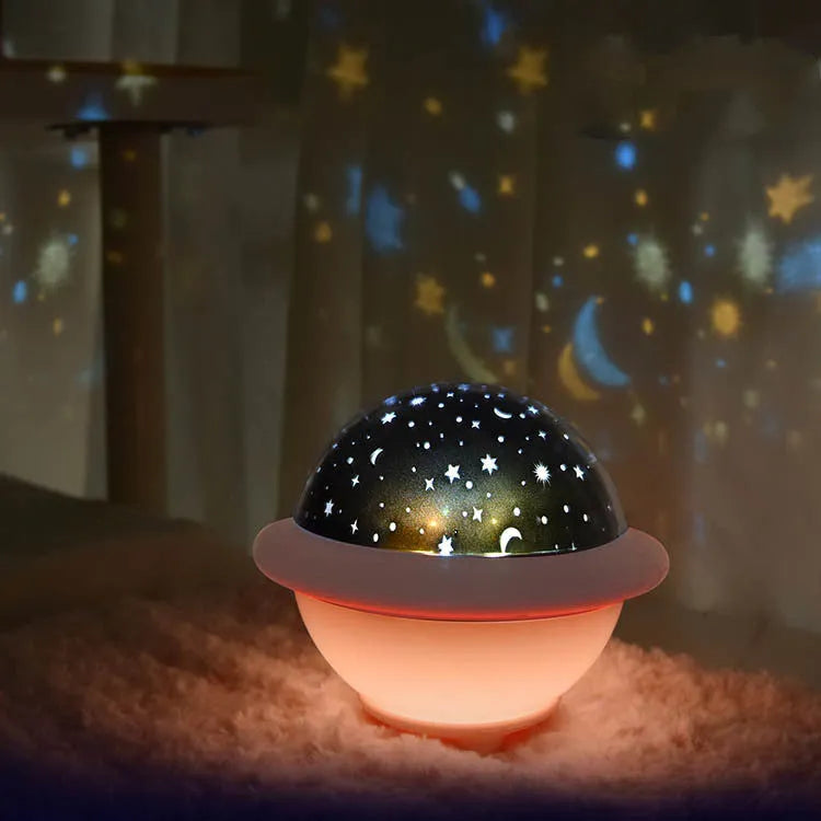 Pink UFO-shaped plastic LED night light projecting starry sky pattern on wall