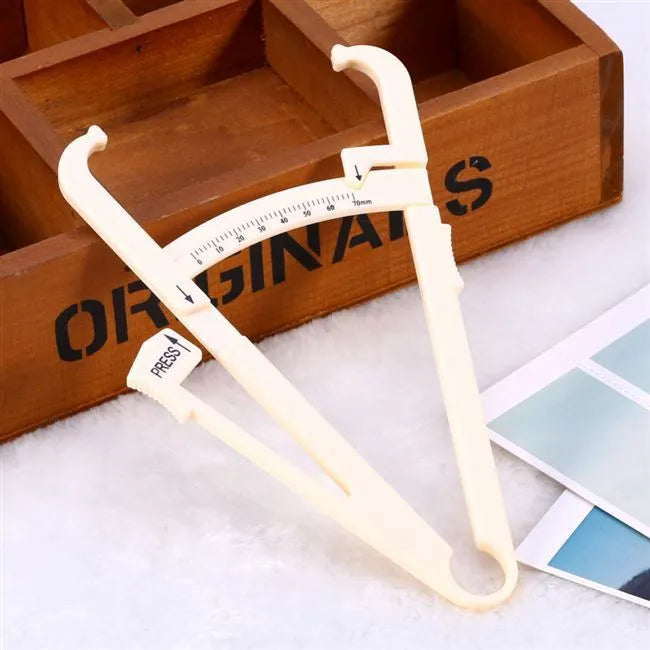 Compact acrylic fat caliper for body fat measurement, showing size and scale.