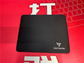 Black thickened rubber mouse pad on a desk, showing its textured surface and substantial 5mm profile.