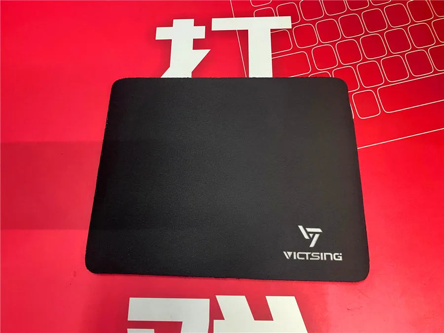 Black thickened rubber mouse pad on a desk, showing its textured surface and substantial 5mm profile.