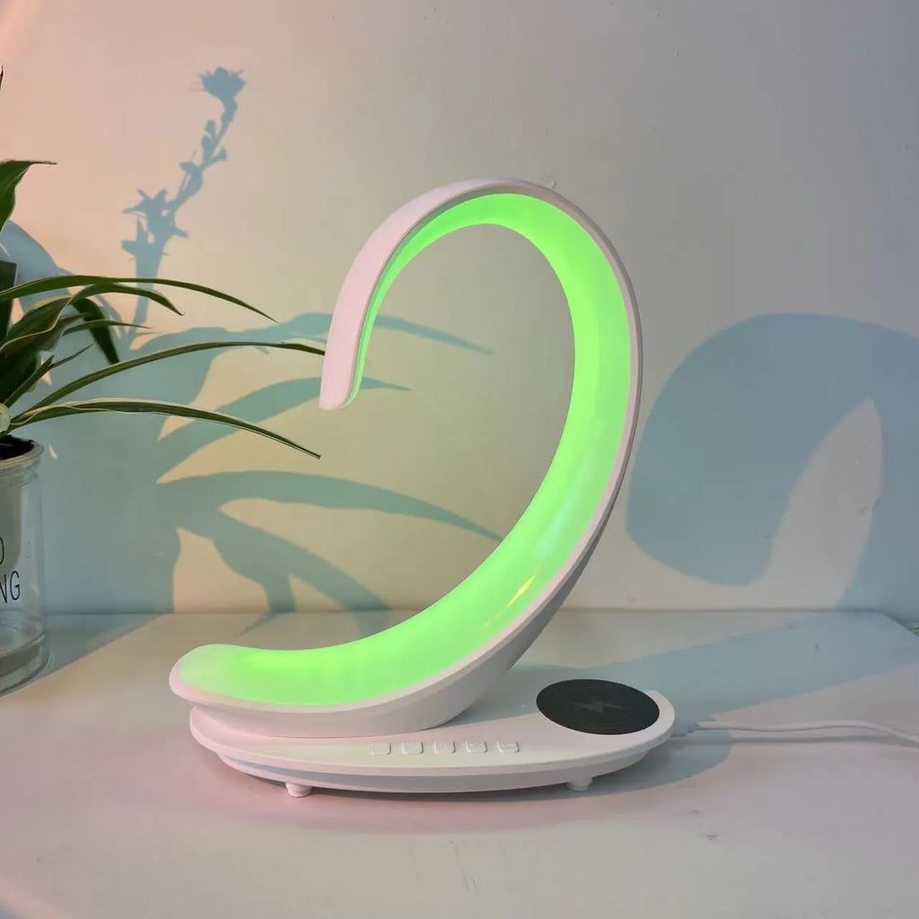 White swan-shaped desktop LED lamp with wireless charging pad and Bluetooth speaker.
