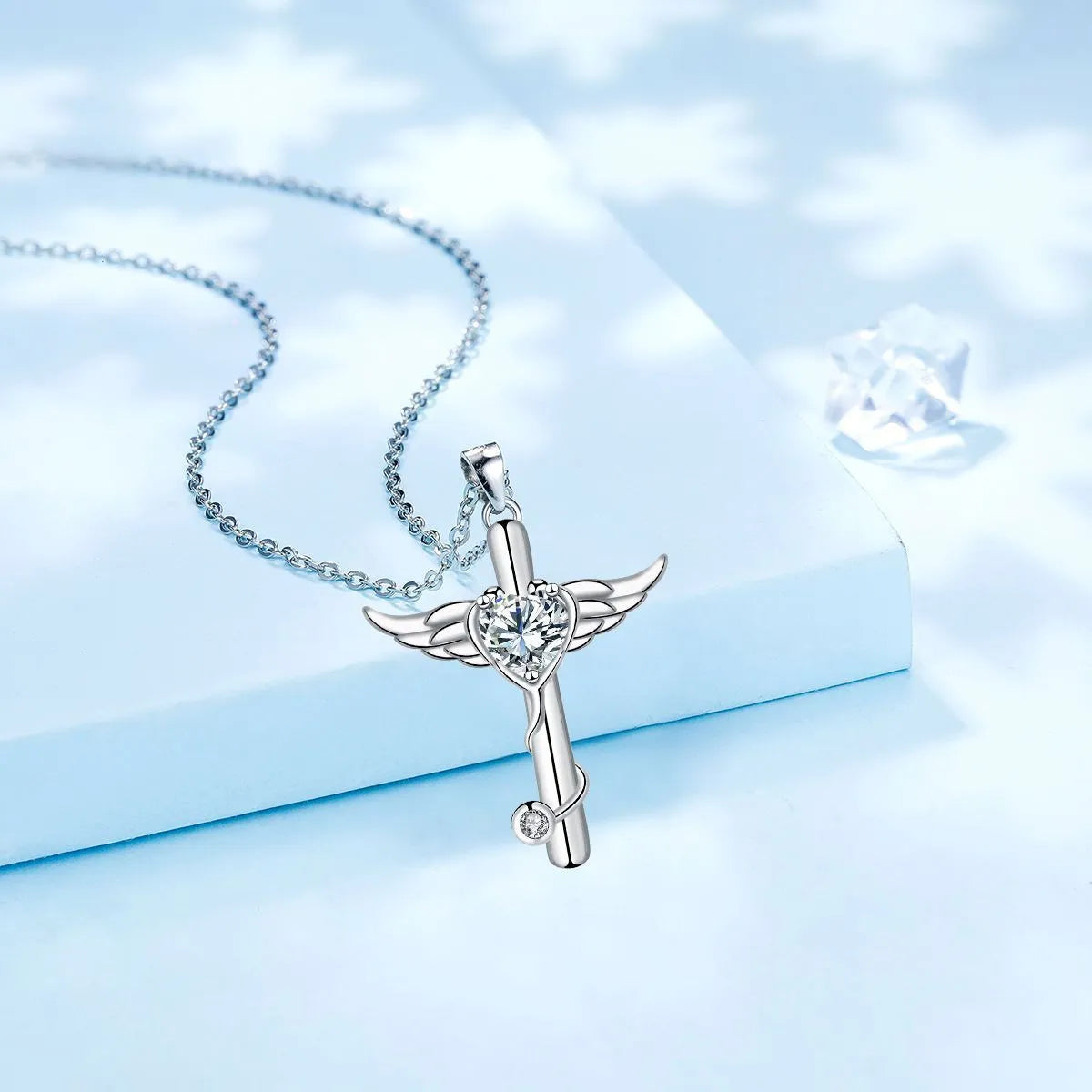 Close-up of a women's necklace with a cross, stethoscope, and wings pendant in electroplated copper.