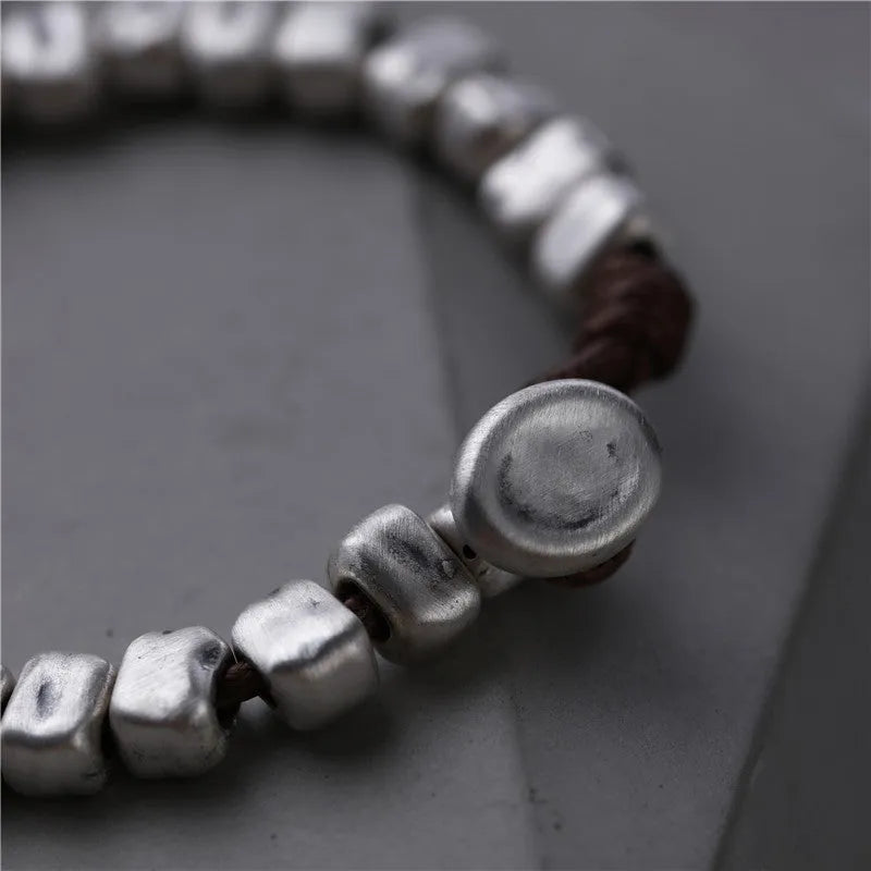 Handmade women's bracelet with an irregular silver square pendant on a wooden elastic band.