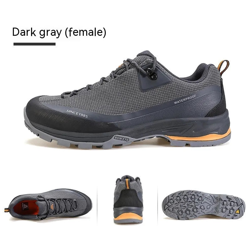 Men's low-top hiking boots in black with leather mesh upper and rubber outsole on a rocky path.