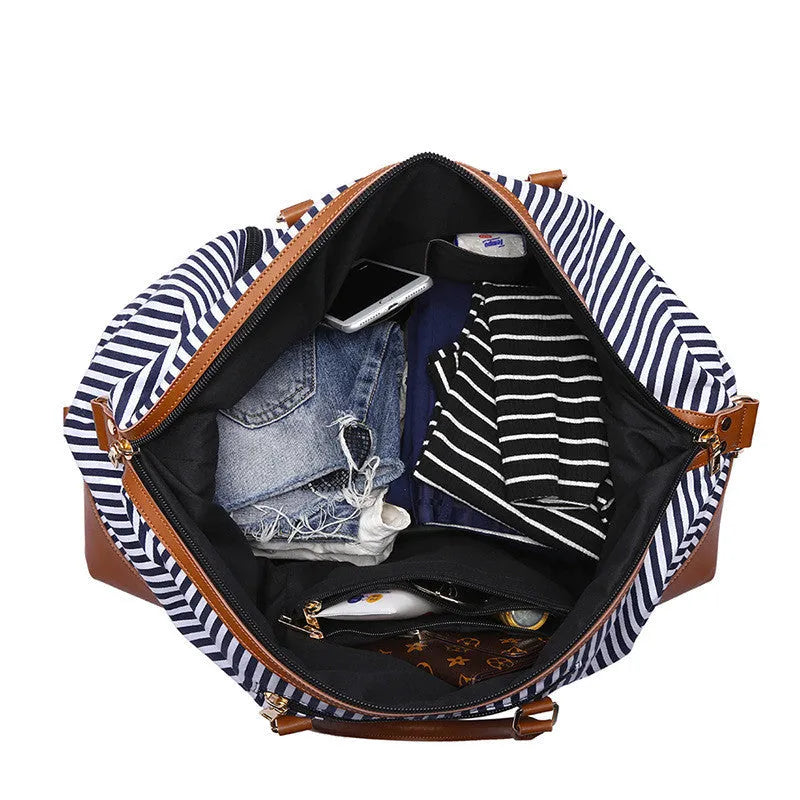 Large blue striped canvas travel bag with single shoulder strap, soft handle, zip opening, and internal pockets.