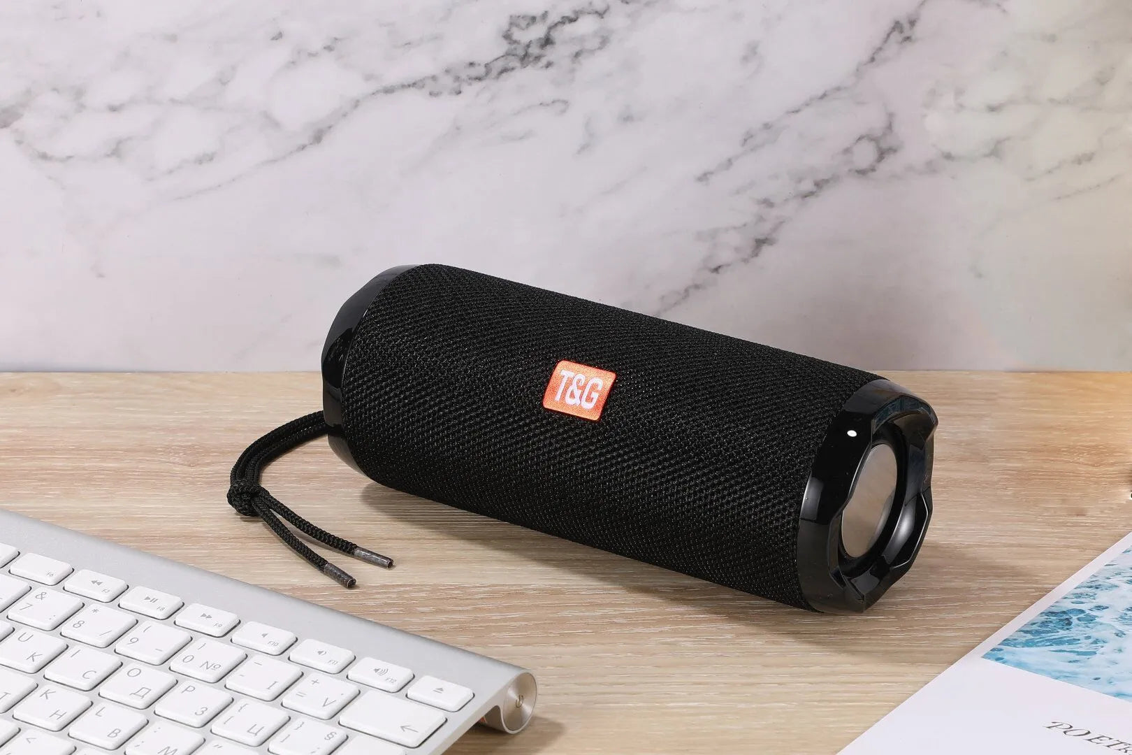 Fabric-covered portable Bluetooth speaker showing the integrated card holder slot, displayed in the camouflage colour variant.
