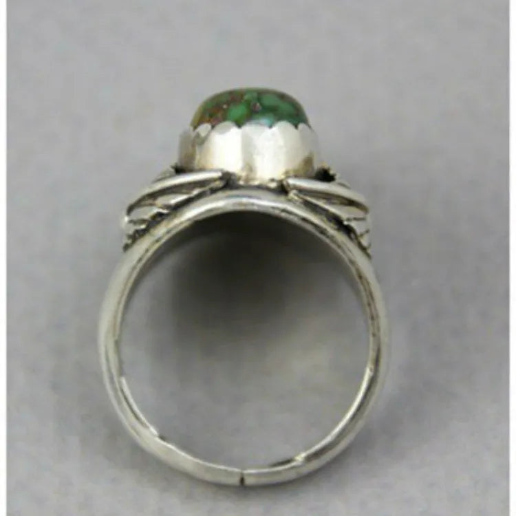 Close-up of a women's geometric ring with a retro turquoise inlay on a grey background.